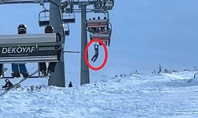 D&uuml;şen snowboardını almak i&ccedil;in atlamaya &ccedil;alıştığı telesiyejde asılı kaldı
