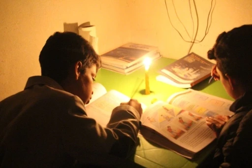 &Ouml;ğrenciler mum ışığında ders &ccedil;alışıyor
