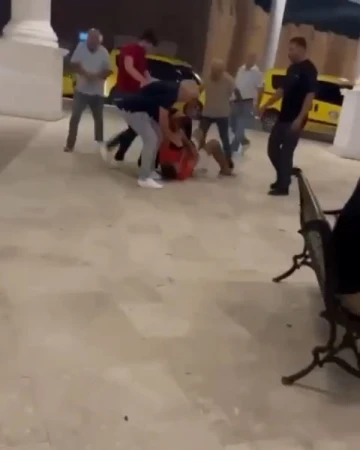 Taksicilerin m&uuml;şteri kavgasında yere yatırılan s&uuml;r&uuml;c&uuml; tekmelerle darp edildi
