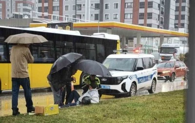 Yağmur altında ıslanan yaralıya trafik polisi şemsiye tuttu