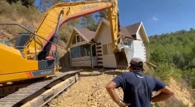 Konteyner evini iş makinesiyle karadan rayla y&uuml;r&uuml;t&uuml;p taşıdı